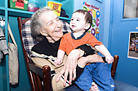 A resident at Isabella Geriatric Center interacts with a youngster from the childcare center.