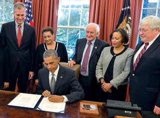 Parkinson (far left) and Minnix (far right) watch President Obama sign the IMPACT Act.