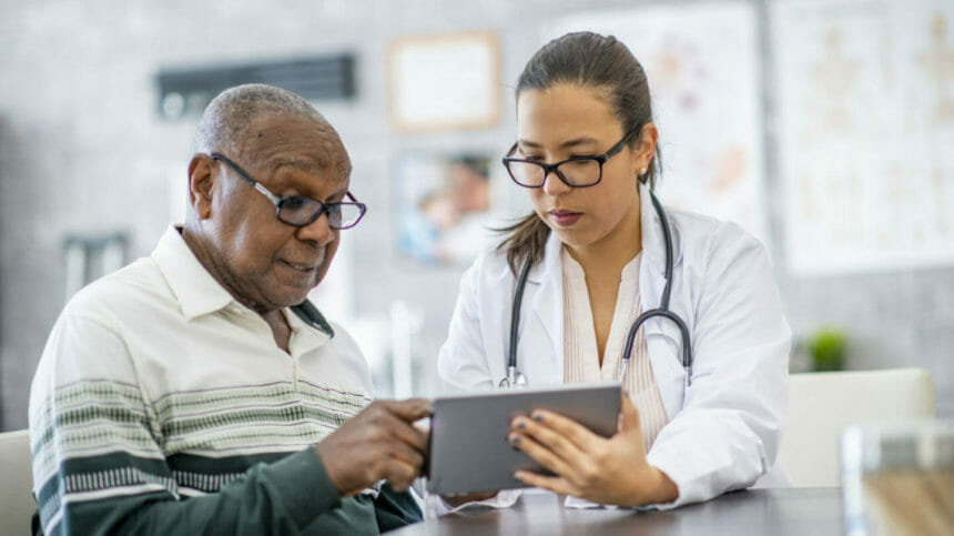 Senior man looking at digital tablet provided by doctor