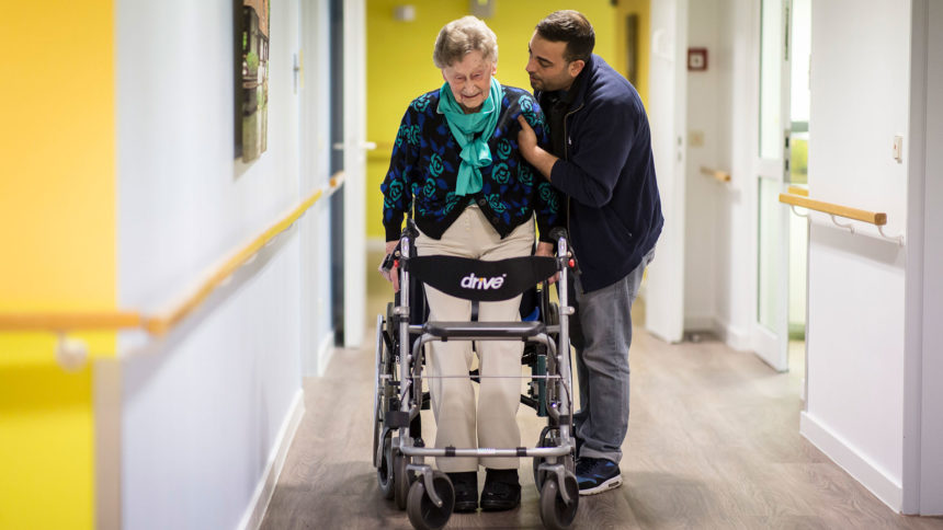 Caregiver helps senior walk