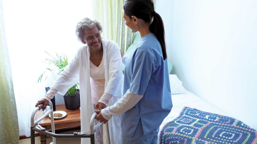 Image of an older women with walker in long-term care setting interacting with healthcare provider