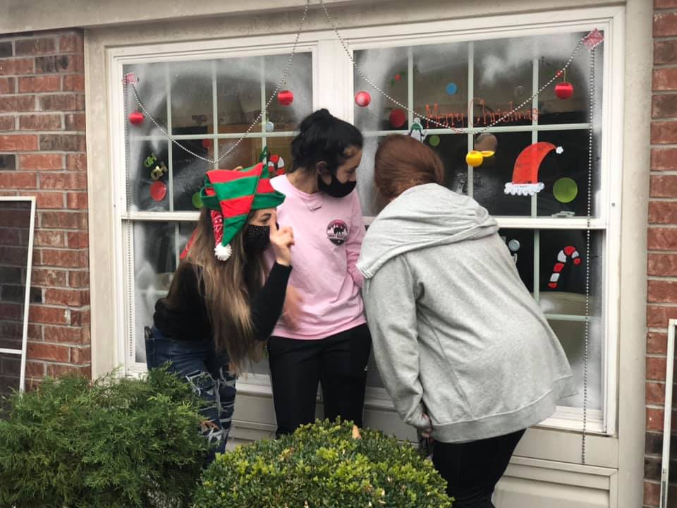 Volunteers, families jump to help decorate dozens of resident windows for holiday