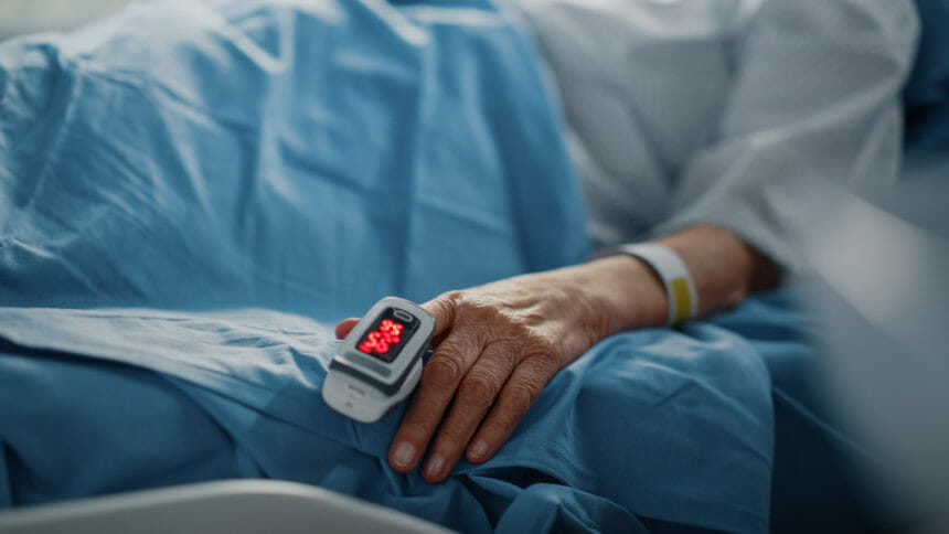 Hand-pulseOximeter-covid-19-bed-ill-illness-sick-infection-infected-resident-nursingHome-GettyImages-1321691734.jpg