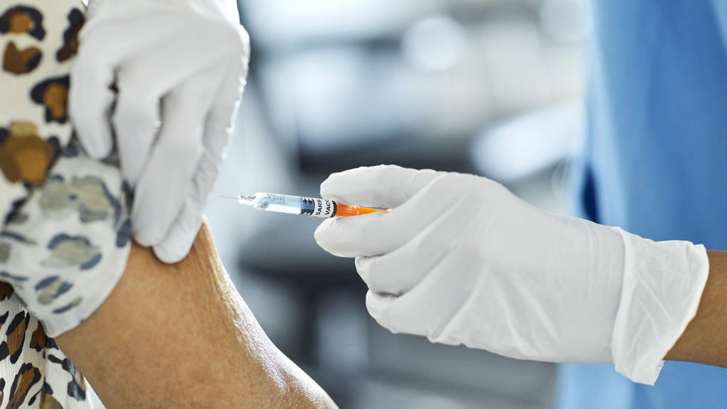 Cropped image of nurse injecting Covid-19 Vaccine to a patient.