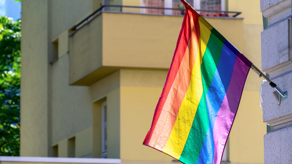 LGBTQ flag hangs on a building