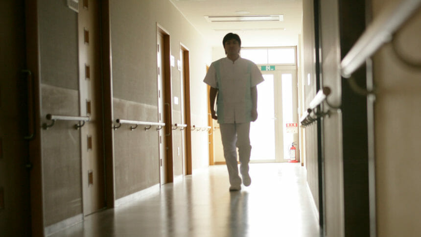 A nurse walking through a long hallway.