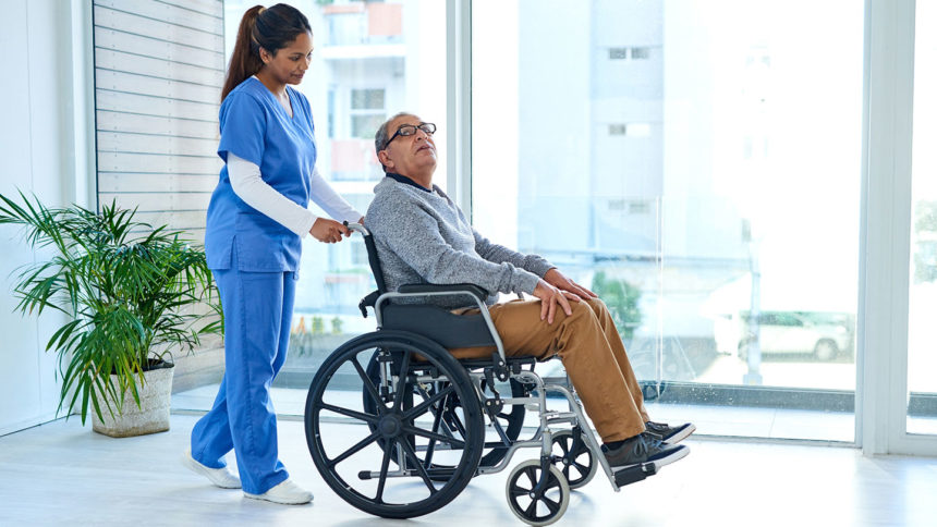 A nurse rolling a senior in a wheelchair