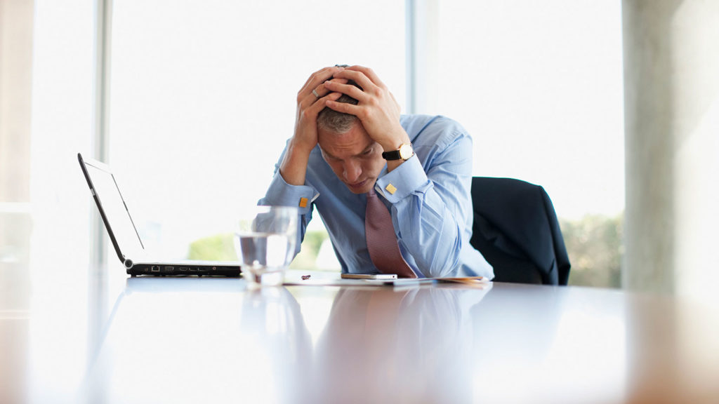 A businessman stressed at his work desk