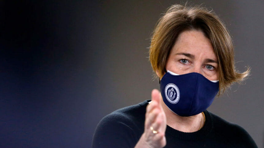 A masked Attorney General Maura Healey speaks during a press conference
