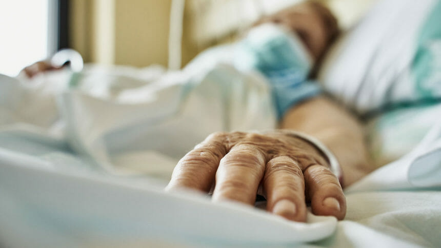 A sick nursing home resident lies in bed