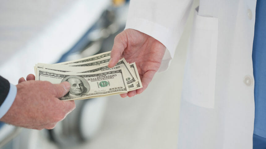 A healthcare worker is handed money