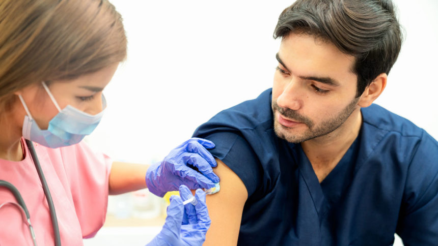 A healthcare worker receives a COVID-19 vaccine dose