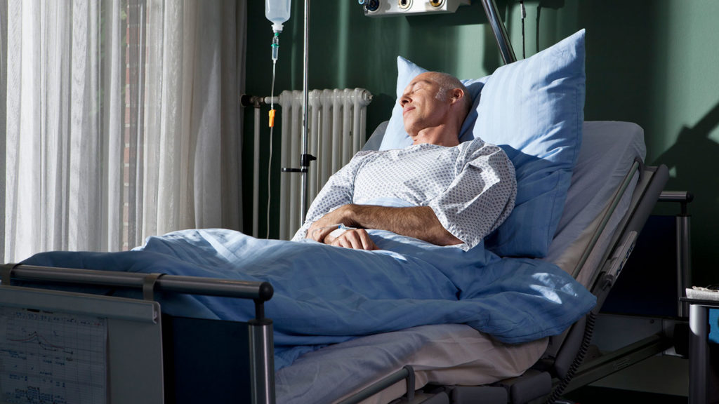 Sick man in hospital bed