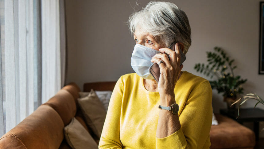 Older woman with face mask talking on phone