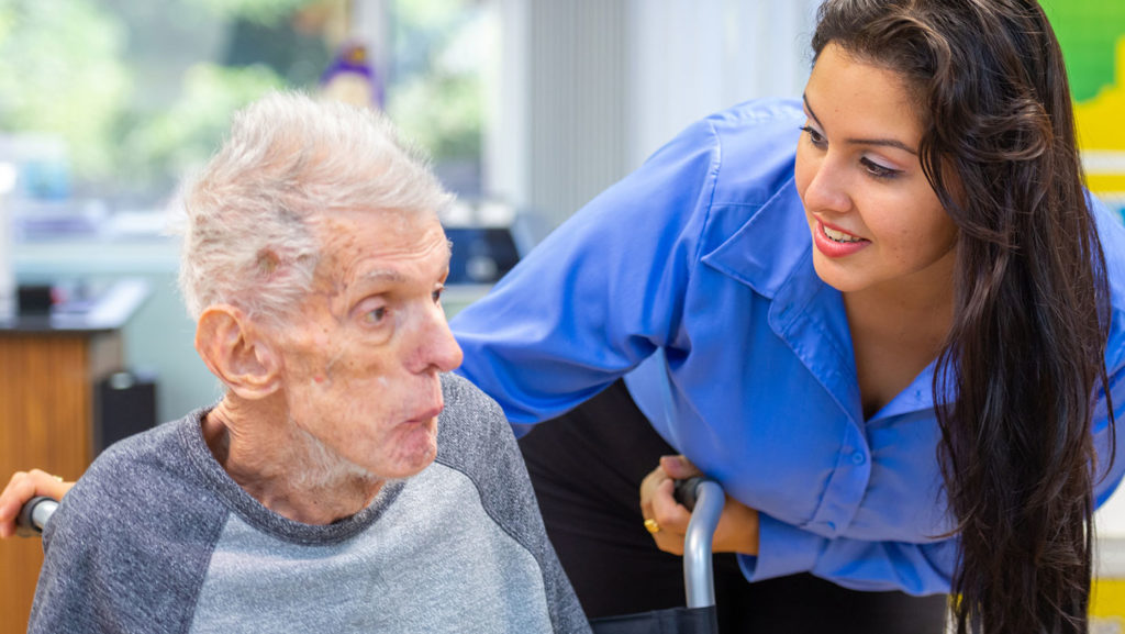 An immigrant nursing home worker helps a resident