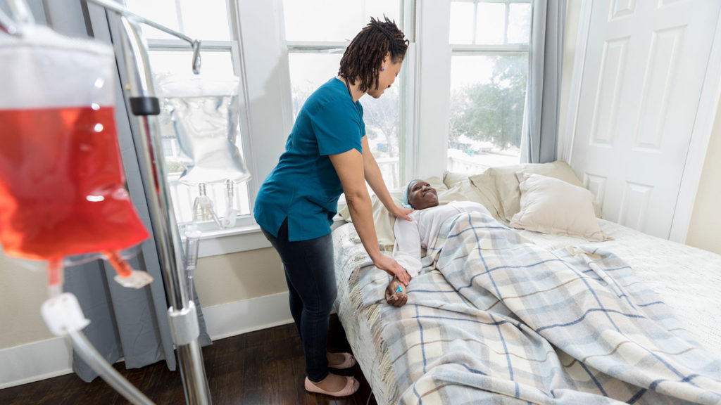 Nurse takes care of a bedridden and sick nursing home resident