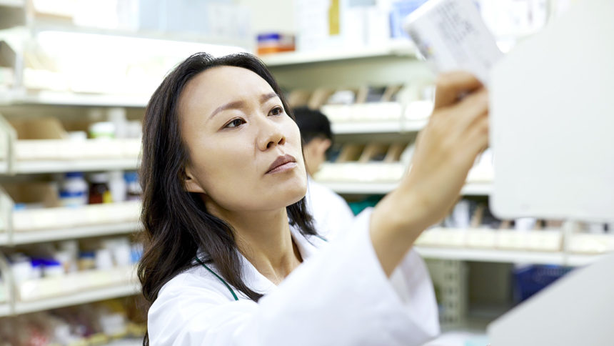 Image of female pharmacist arranging drugs on shelf