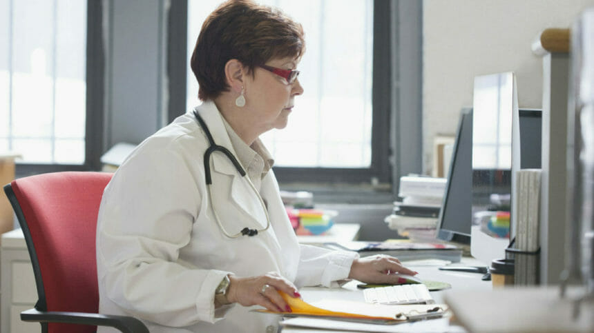 Image of doctor using computer at desk