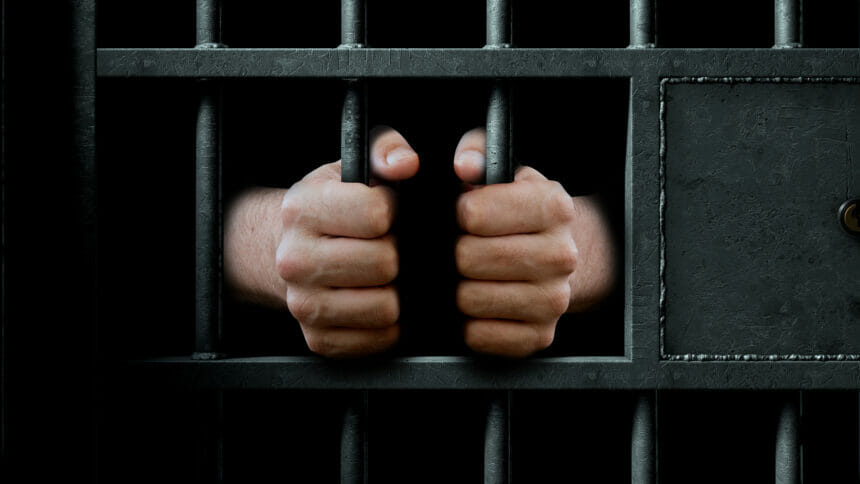 Hands behind prison bars