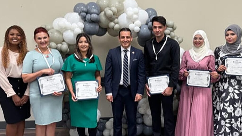 refugees pose for picture with diplomas after completing training program