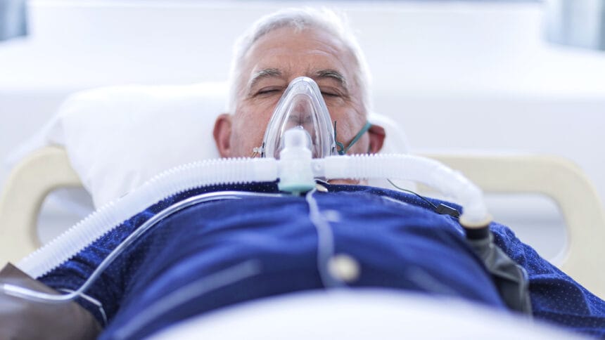 patient in hospital bed on ventilator